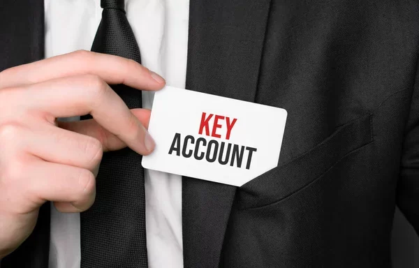 depositphotos_476728902-stock-photo-businessman-holding-card-text-key